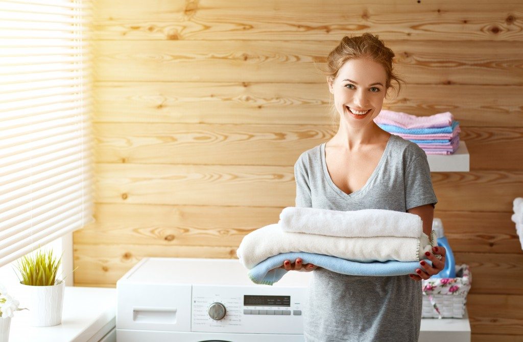 a Happy housewife woman in laundry room with washing machine