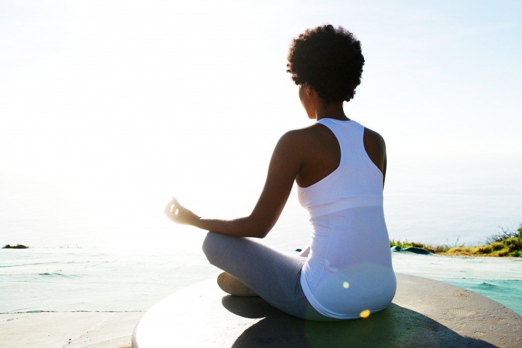 Woman meditating in front of the beach