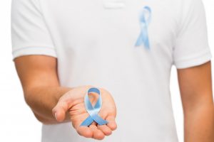 Man holding blue prostate cancer awareness ribbon