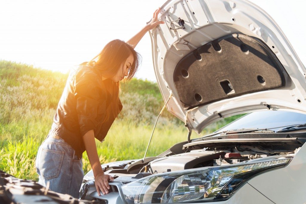 Woman opening car hood