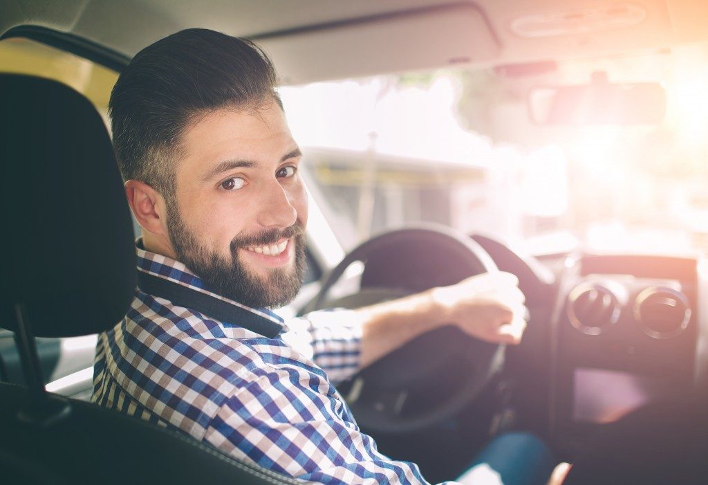 man inside his car smiling