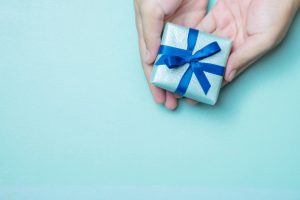 hands holding a gift in a blue background