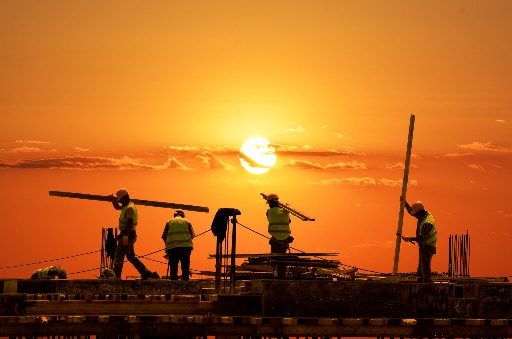 workers constructing building during the sunset