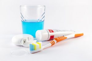 Toothbrush, dental floss, toothpaste and mouthwash on white background